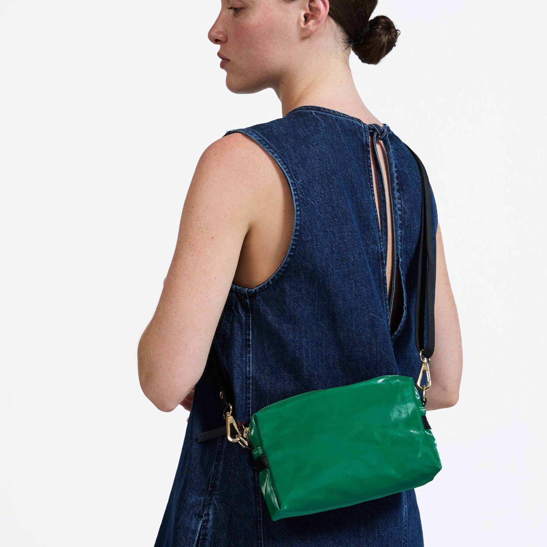 Woman wearing a green handbag on a white background