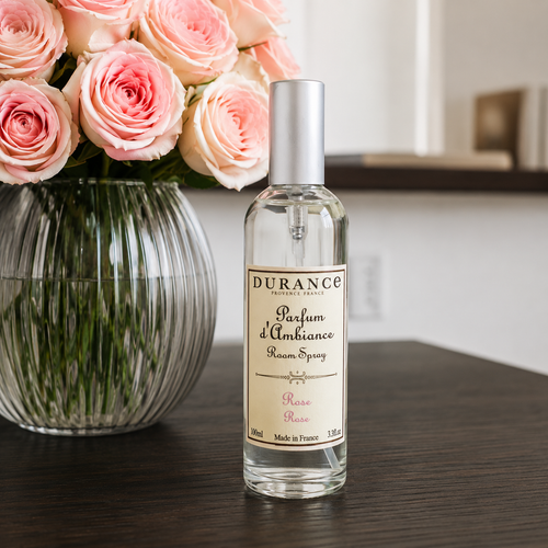 Designer scented candle against succulent foliage 