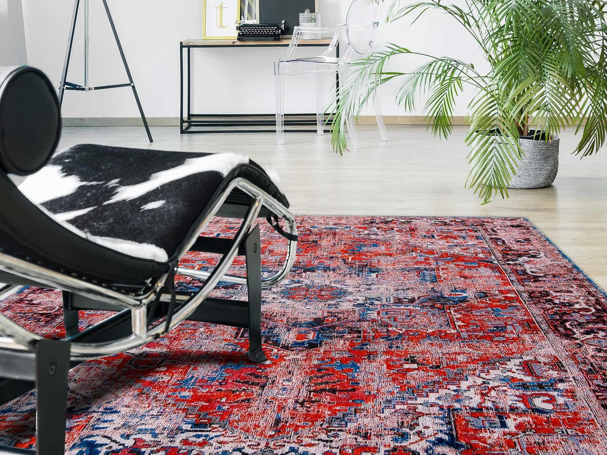 faded rug in red tones with blue detail in livingroom on white floor