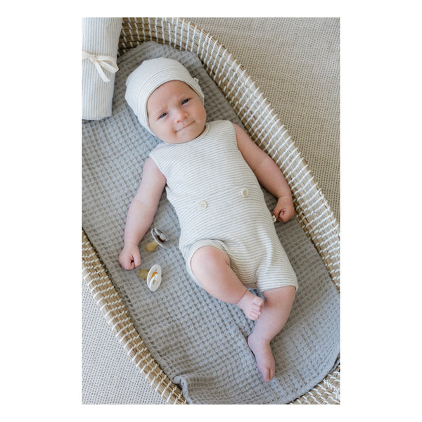 White organic cotton jumpsuit short sleved on baby in crib